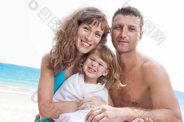 年轻家庭在海滩上玩耍的照片