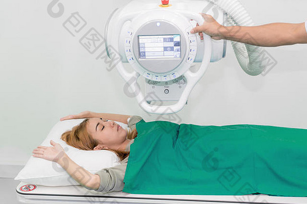 亚洲年轻的女人病人说谎x射线设备放射科医生准备机x射线房间医院