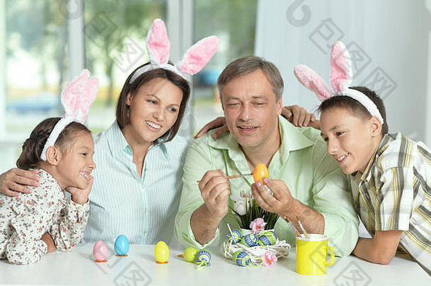 快乐家庭穿兔子耳朵绘画复活节鸡蛋