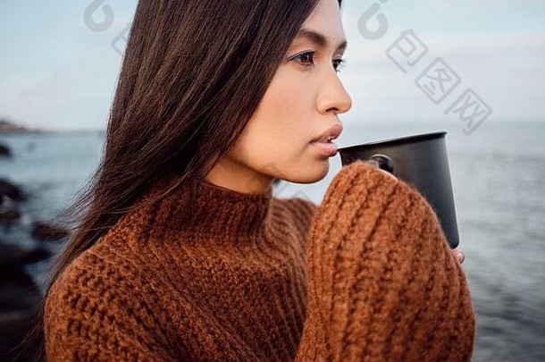 一边视图漂亮的亚洲浅黑肤色的女人女孩舒适的针织毛衣杯子深思熟虑海边