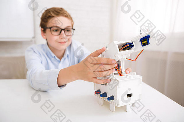 聪明的男孩在工程课上测试他的机器人设备