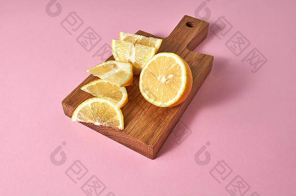 多汁的黄色成熟柠檬片-用于制作天然<strong>排毒</strong>饮料的食材。柑橘类水果放在一块粉红色的木板上。