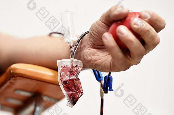 一名献血者的手和一个医院的塑料血袋的细节