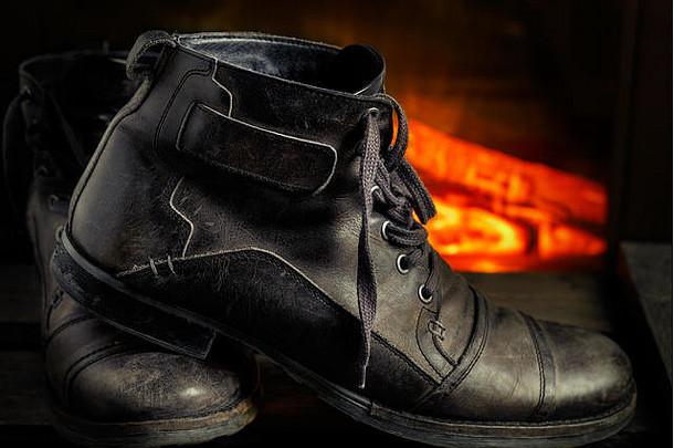 背景为壁炉的木板上男士休闲灰色皮鞋。黑暗情绪风格。水平图像。