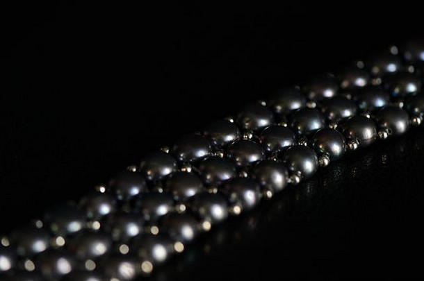 黑色珍珠项链，深色背景特写
