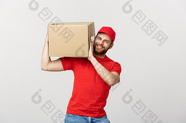 递送理念：年轻白种人英俊的递送员肩上扛着一个盒子。在灰色背景上隔离。