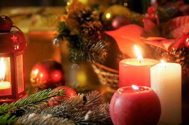 木桌上燃烧着蜡烛和圣诞装饰品的特写图片。非常适合寒假和庆祝活动
