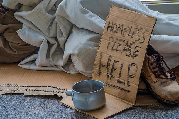 无家可归的一个戴着黑手套的不幸的无家可归者牵着手从人们那里得到<strong>零钱</strong>或帮助捐赠食物。