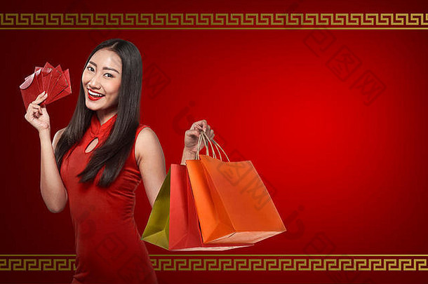 亚洲女人旗袍衣服持有报业购物袋快乐中国人一年概念