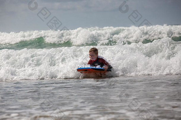 威尔士彭布罗克郡海滩上<strong>冲浪</strong>的小<strong>男孩</strong>。