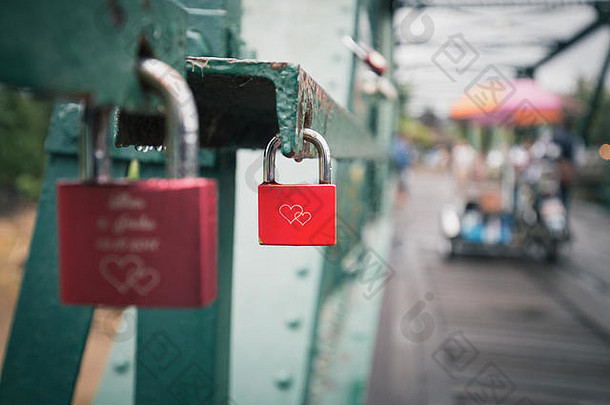密切关注老红锁，两颗心锁在老桥的绿墙上。人们为了永远的爱而来挂锁。