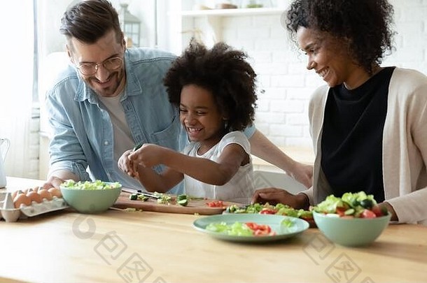 幸福的多民族家庭与女儿一起在家做饭