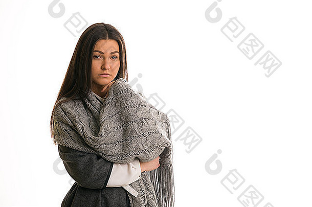 一个戴灰色针织围巾的年轻女子很伤心。
