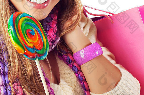 图片漂亮的女人吃甜蜜的糖果可爱的女孩完美的微笑持有粉红色的购物袋