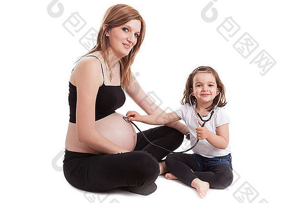 小女孩用白色背景的听诊器检查怀孕的母亲