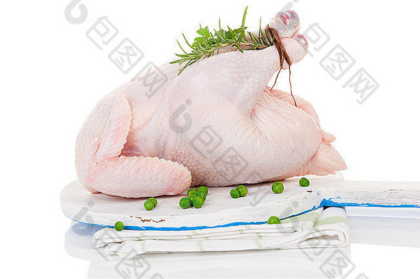 生的有机全鸡，切菜板上有香草，白色隔离，准备烘烤。烹饪。