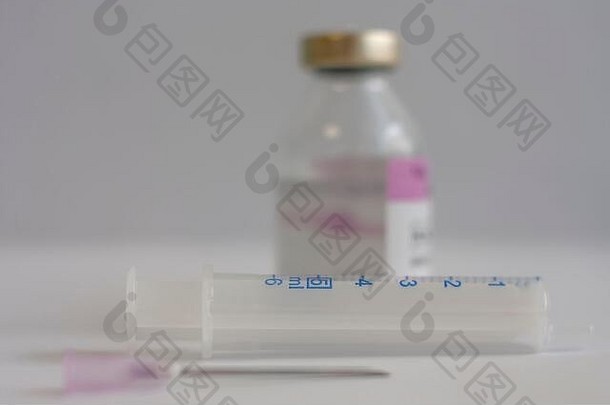 注射器特写镜头，背景瓶抗生素，用于治疗冠状病毒19型肺炎患者的注射药物。