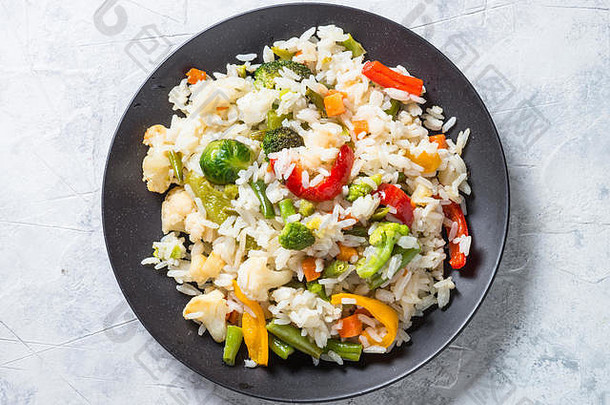蔬菜意大利饭。米饭配西兰花、花椰菜、甜椒和胡萝卜。素食。俯视空间。
