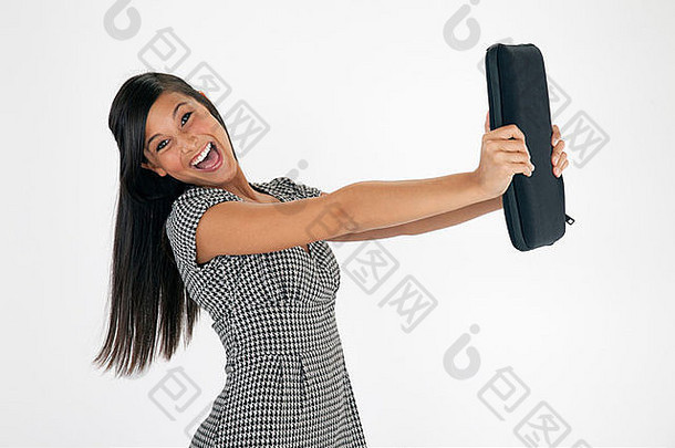 一位年轻漂亮的亚洲女士在白色背景下举着一个笔记本电脑盒时笑了起来。水平射击。