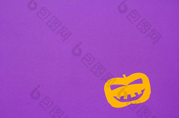 万圣节背景装饰节日概念。紫色桌子上杰克O南瓜笑脸剪纸的极简平面视图。