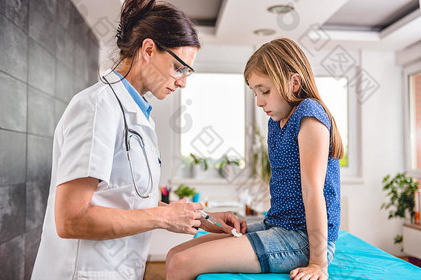 儿科女医生给年轻的女孩疫苗拍摄腿