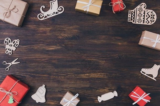 上图圣诞节装饰的高角度照片x-mas装饰组成礼品盒木制冰鞋手套雪橇糖果手杖放在棕色的地板上