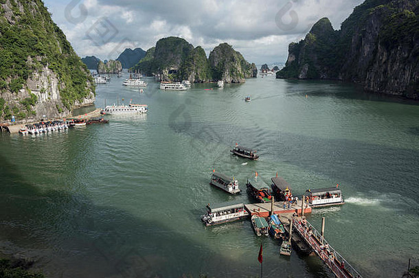 越南北部下龙湾太阳洞（惊喜洞）入口外的旅游船和旅游船