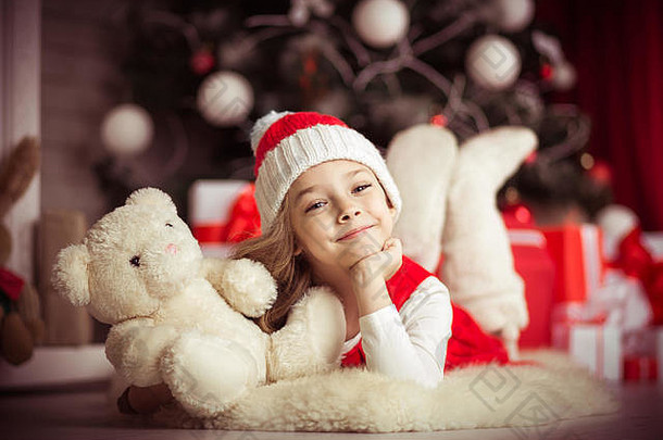 可爱的女孩圣诞老人他地板上圣诞节树熊工作室拍摄爽肤水古董风格