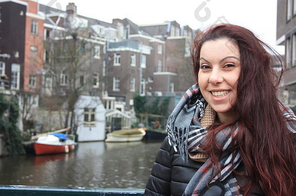 红头发的白人女孩在秋冬季节穿着保暖的衣服在荷兰阿姆斯特丹的街道之间御寒