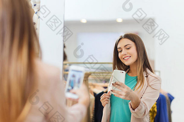 女人采取镜子自拍智能<strong>手机</strong>商店