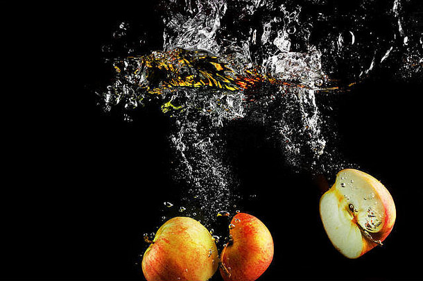 新鲜的苹果下降水飞溅空气泡沫健康的食物黑色的背景洗水果