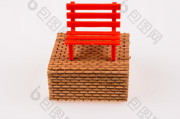 稻草箱上的红色塑料长凳