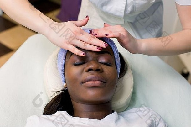 美丽的非洲裔美国女孩在spa沙龙闭眼面部按摩