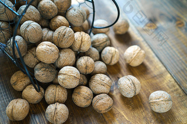 在古老的棕色木质背景上，以原汁原味的有机胡桃壳为质朴风格。从乡下收割坚果。健康的饮食成分。闭合。