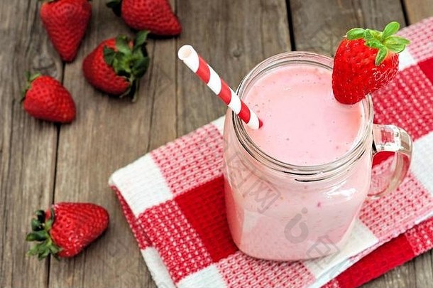 梅森健康草莓奶昔一个用方格布垫在粗木上的罐子马克杯