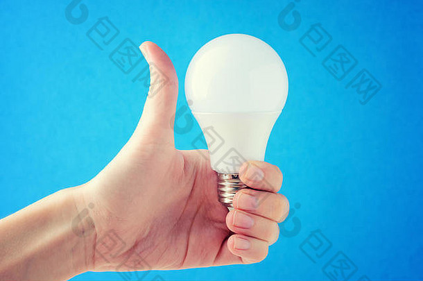 女人持有光灯泡手显示喜欢概念能源保护手能源储蓄光灯泡蓝色的
