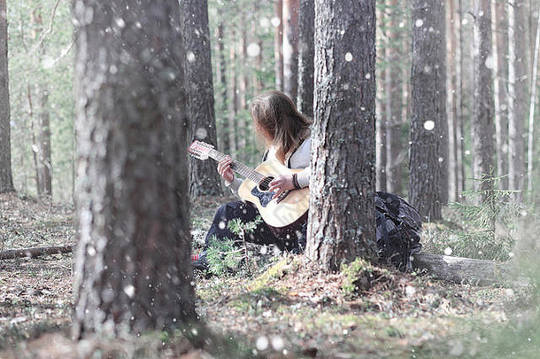 野餐时在树林里的吉他手。一个有声乐器的音乐家