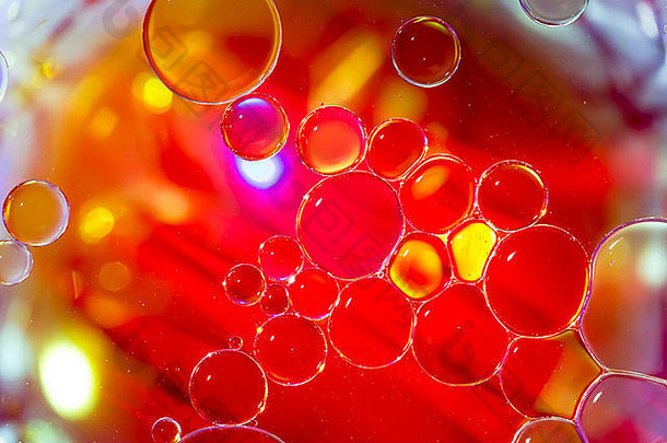 漂浮在水面上的气泡。不同的颜色和灯光营造出抽象的外观。颜色主要是橙色、黄色和金色。