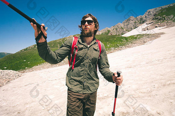 带着<strong>登山杖</strong>的年轻人背着背包在户外旅行生活方式概念山上度过暑假