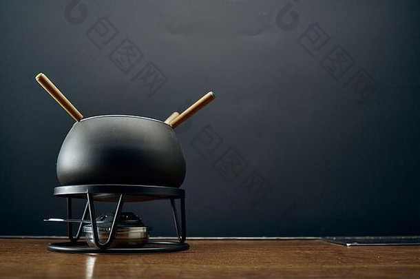 厨房场景黑色的锅烹饪芝士<strong>火锅</strong>站木表格黑色的背景