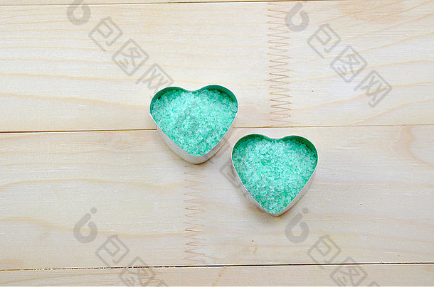 绿色的海盐颗粒放在木桌上的心形盒子里
