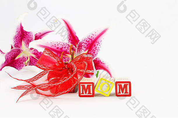 <strong>字母</strong>块拼出妈妈，放在礼物和鲜花前。