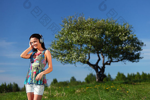 戴着耳机在球场上听音乐的年轻女子
