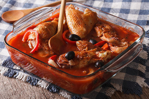 美味的鸡炖番茄酱汁橄榄胡椒玻璃碗特写镜头水平