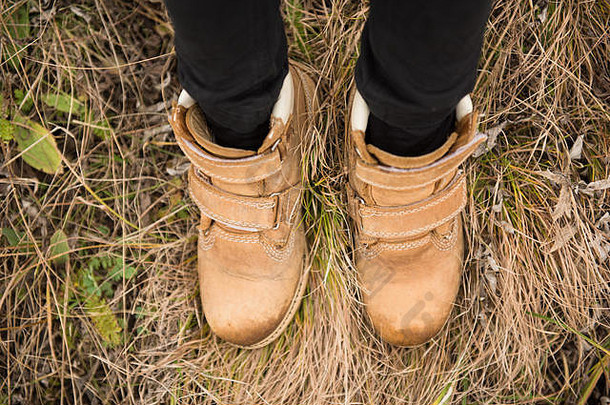 时尚时尚的棕色皮靴儿童脚户外草地秋冬季节