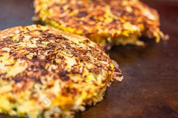 特写一份okonomiyaki日本煎蛋卷，意思是按照你的喜好烹调，用卷心菜丝制作，两面放在热盘子上烹调。