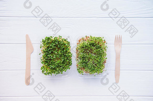 前视图塑料盒子新鲜的有机发芽<strong>微</strong>绿色木餐具白色表格健康的生饮食食物概念复制空间特克斯