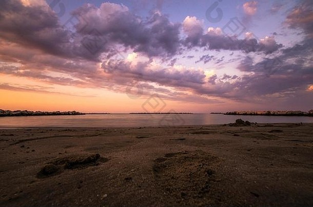 日落时，海滩和平静的大海呈现出五颜六色的海景