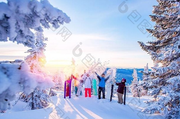 滑雪板和滑雪者组成的快乐团队，享受着抛雪的乐趣。冬季森林日出中的阳光