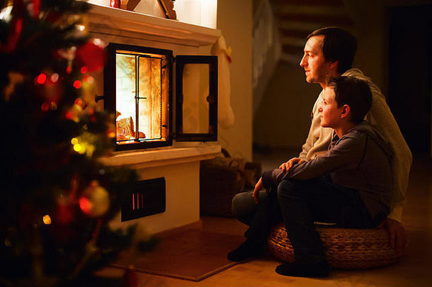 平安夜，父亲和儿子坐在家里的壁炉旁